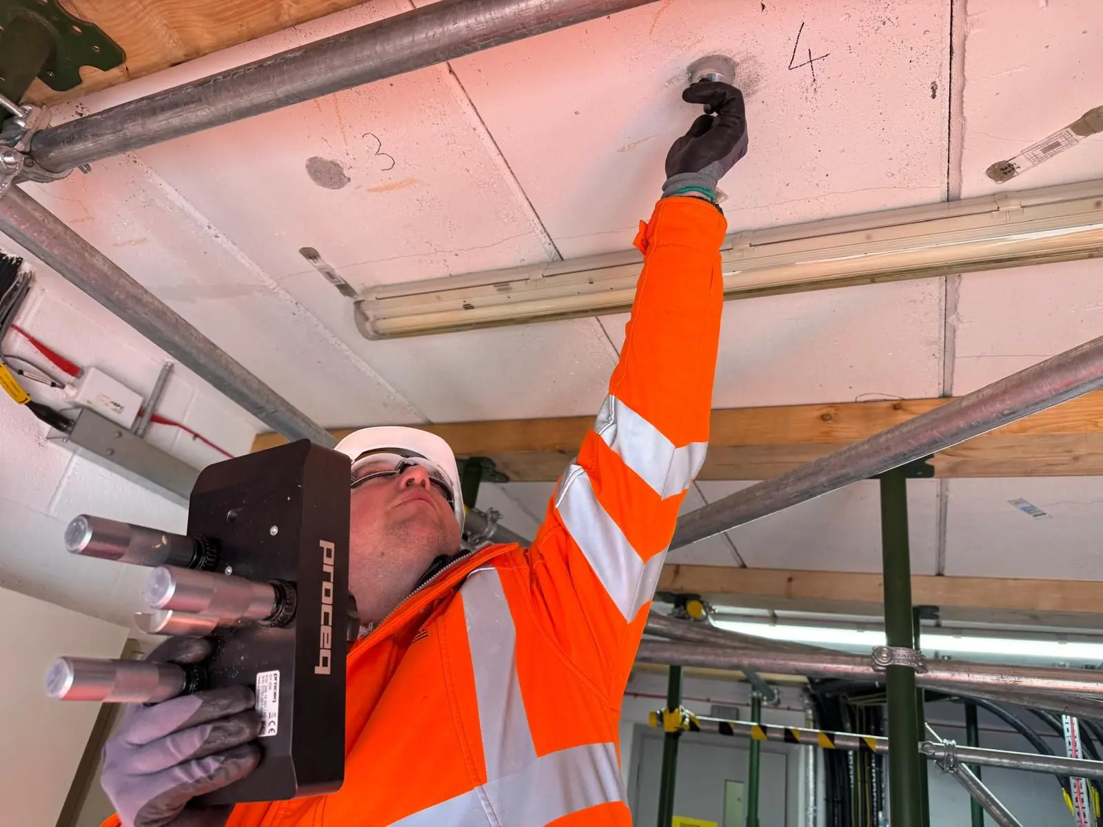 Specialist scanning a soffit from a scaffold