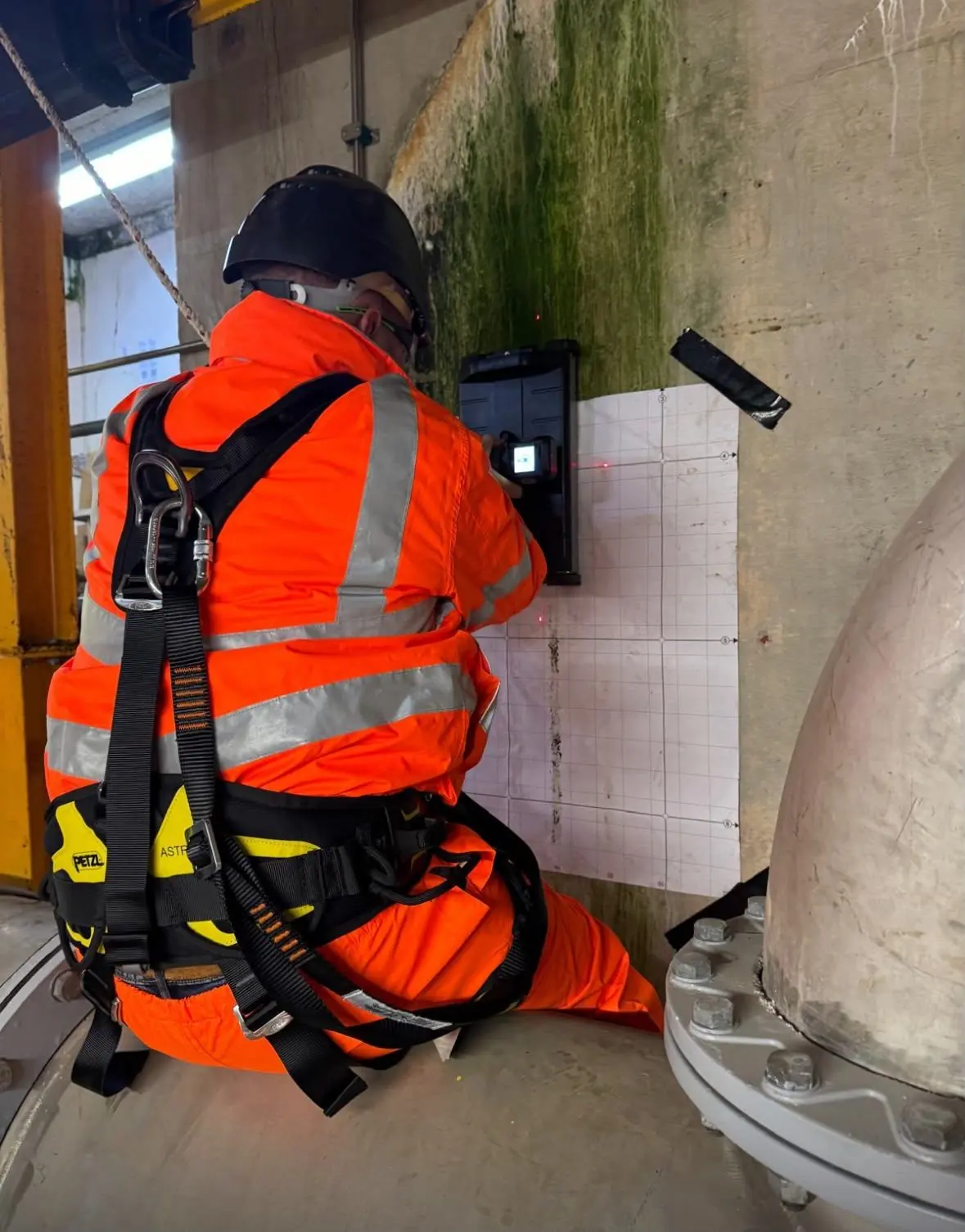 NDTScan operative in a harness scanning a concrete wall with ground penetrating radar