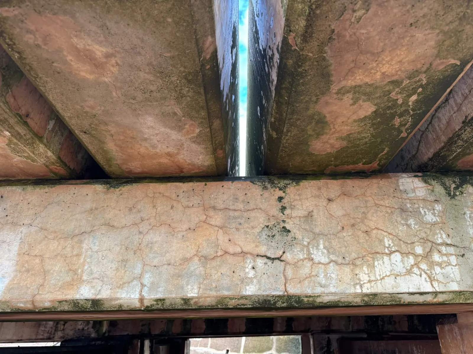 Concrete jetty soffit and steel pile seen from beneath