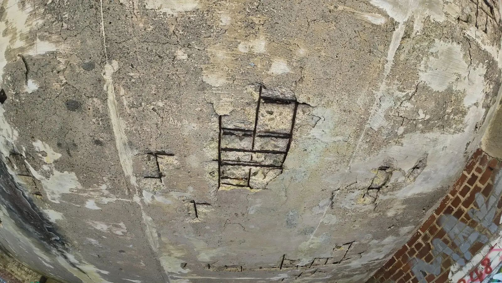Spalled concrete soffit with reinforcement exposed