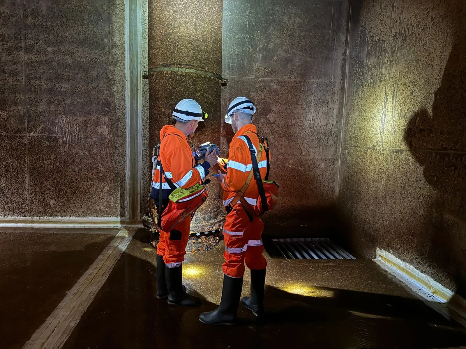 Two NDTScan operatives inspecting the inside of a drained water tank